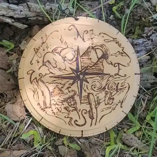 Compass with a desert, ocean, forest, and mountainscape in the four corners.
